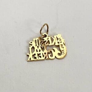 Gold pendant with intricate design and loop.