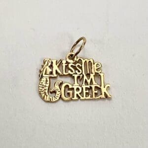 Gold charm reading "Kiss Me I'm Greek.