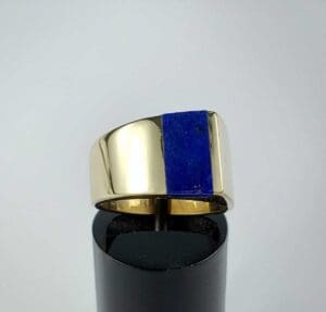 Gold ring with blue rectangular stone.
