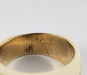 Gold ring with engraved initials inside.