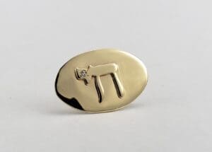 Gold oval pin with Hebrew letter.
