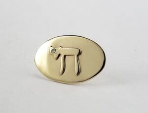 Gold oval ring with Hebrew symbol.