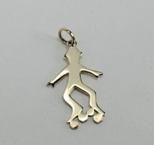 Gold skater pendant with roller skates.