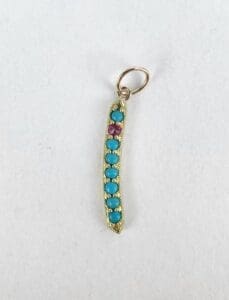Gold pendant with turquoise and purple stones.
