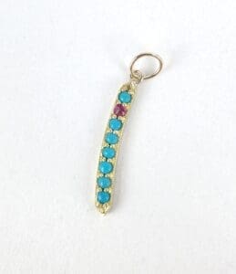 Gold pendant with turquoise and pink stones.