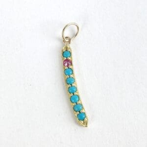 Gold pendant with turquoise and pink stones.
