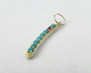 Gold pendant with turquoise and pink stones.