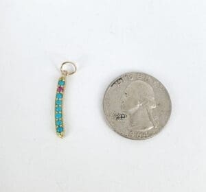 Earring charm beside a 1964 quarter coin.