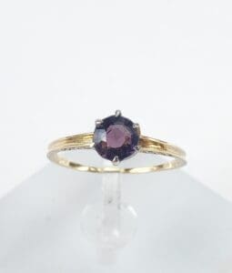 Gold ring with a dark gemstone.