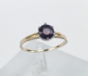 Gold ring with a purple gemstone.