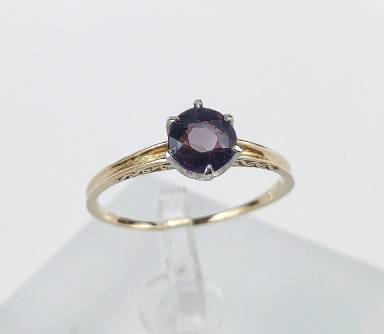 Gold ring with a purple gemstone.