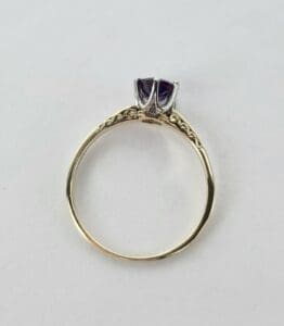 Gold ring with purple gemstone setting.