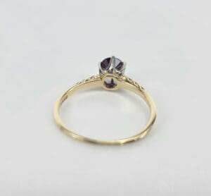 Gold ring with a purple gemstone.