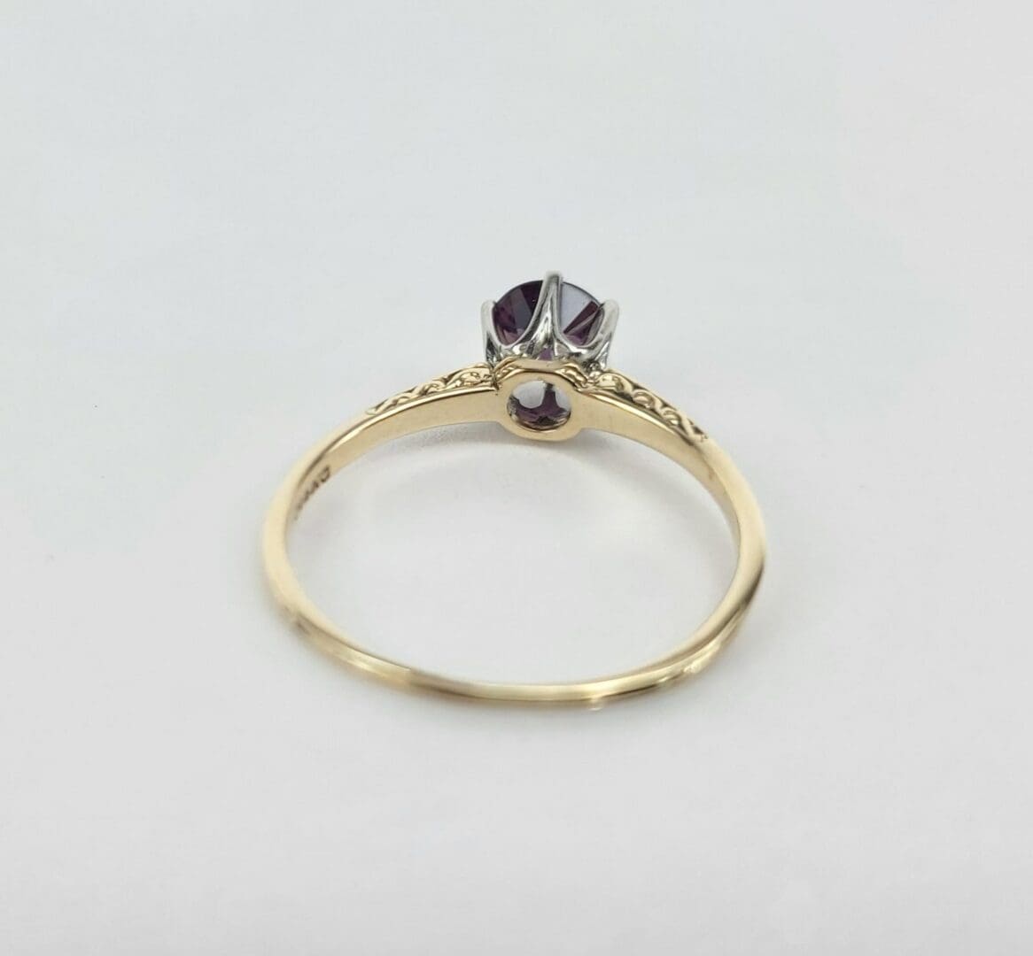 Gold ring with a purple gemstone.