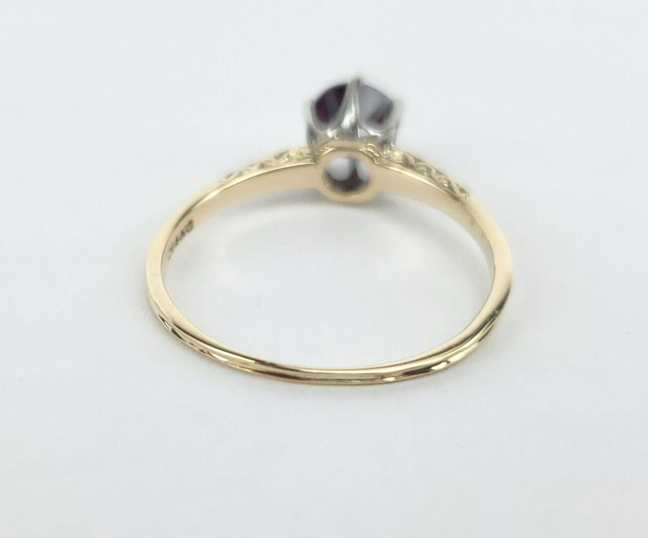 Gold ring with gemstone on white background.