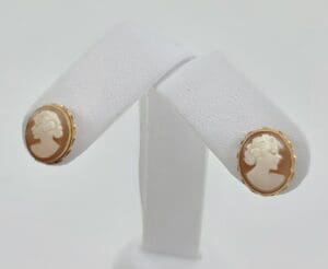 Cameo earrings on white display stand.
