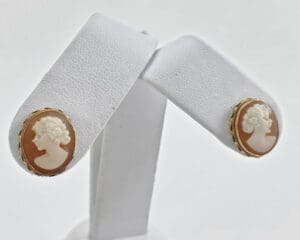 Cameo earrings on white display stand.