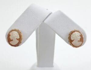 Cameo earrings on white display stand.