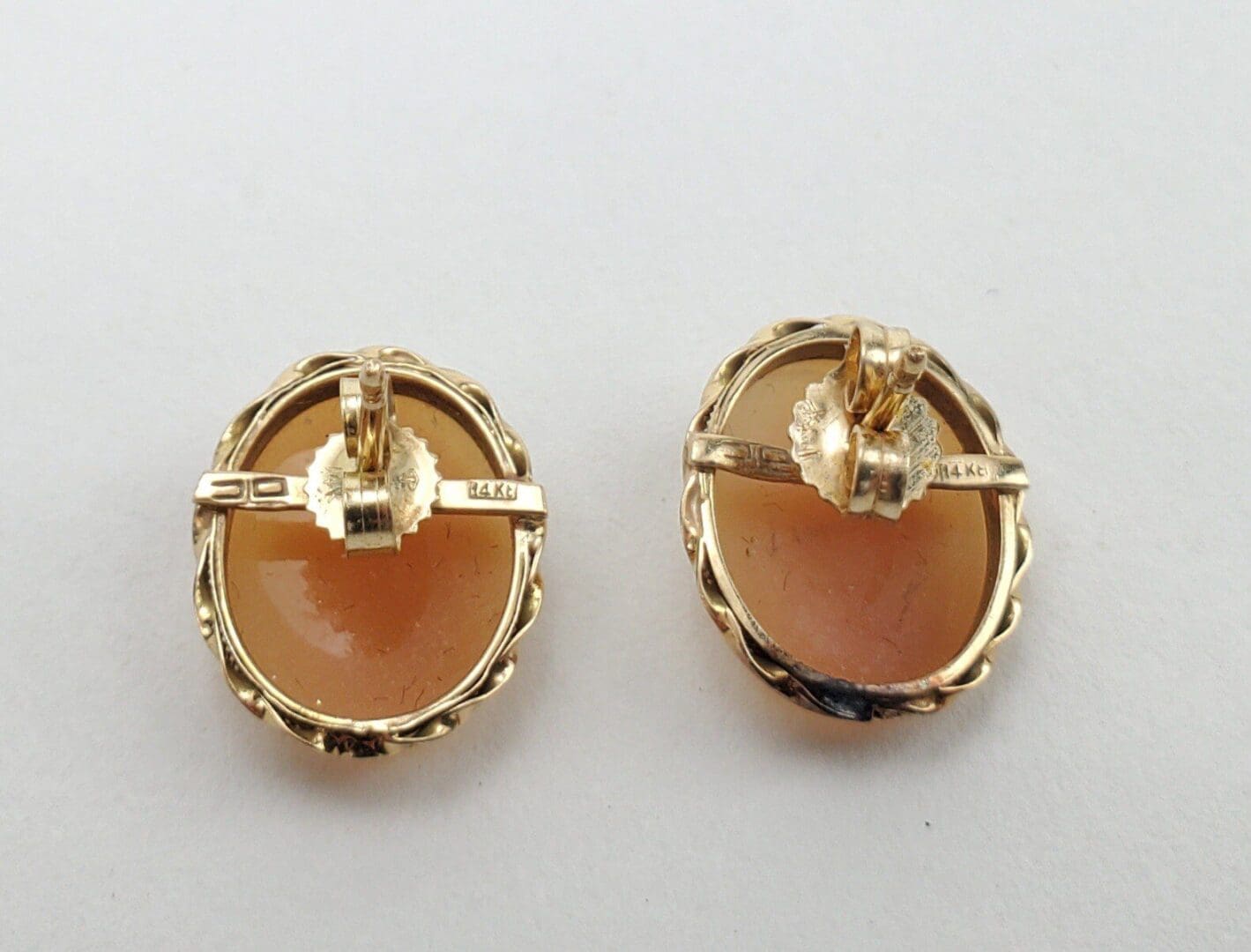 Gold oval clip-on earrings with stone.