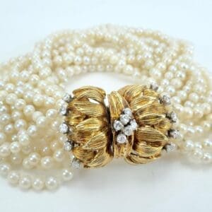 Pearl bracelet with ornate gold clasp.