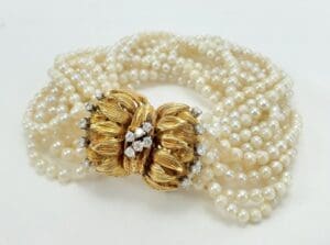 Pearl necklace with ornate gold clasp.