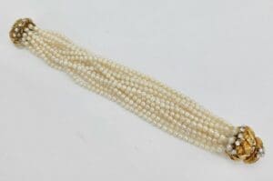 Multi-strand pearl necklace with gold clasps.