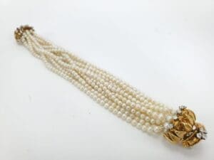 Pearl necklace with gold and diamond clasp.