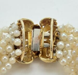 Gold clasp with pearl strands.