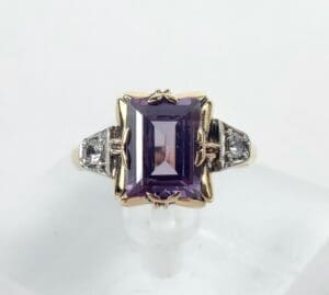 Gold ring with large purple gemstone.
