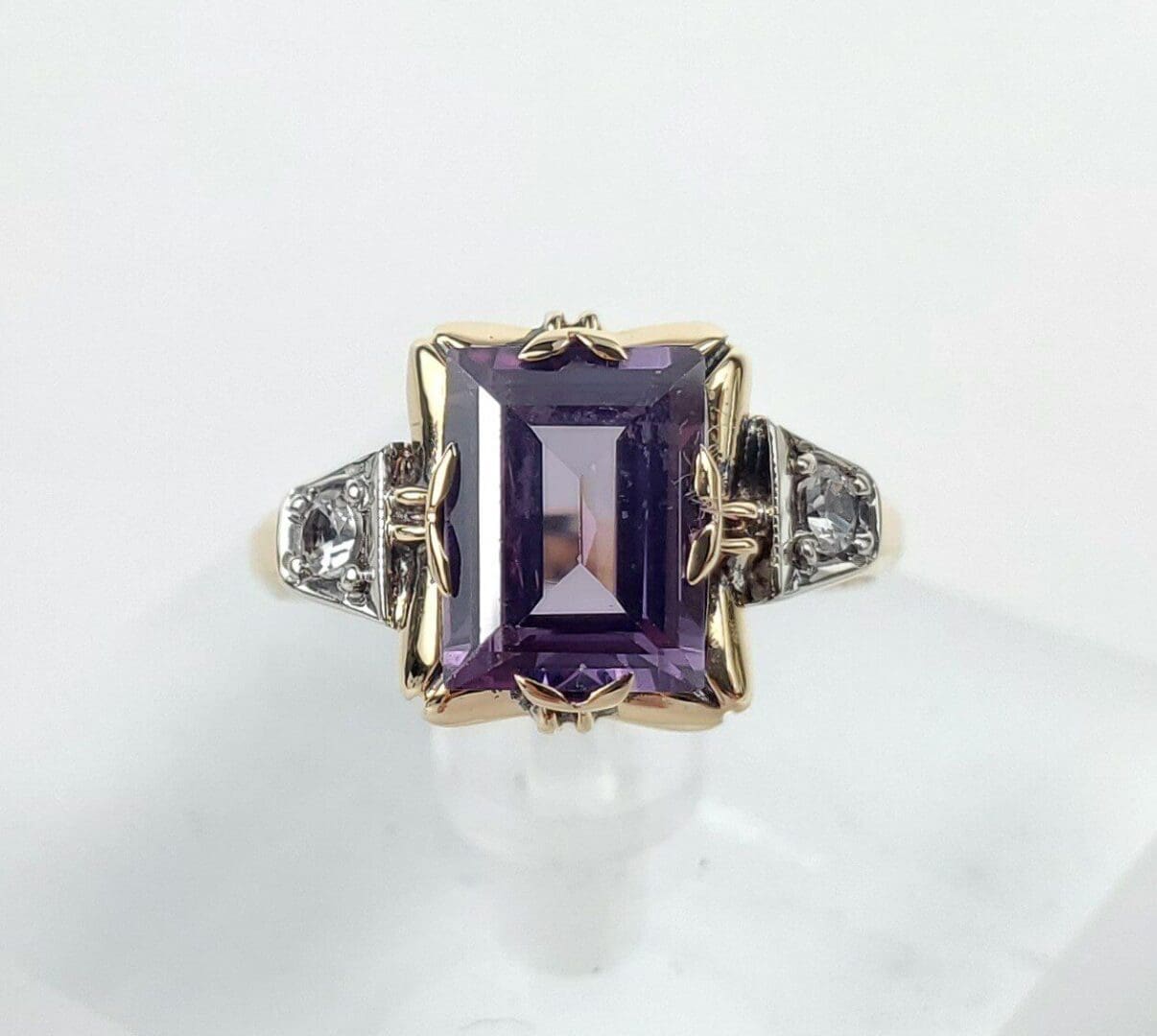 Gold ring with large purple gemstone.