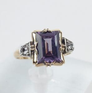 Gold ring with large purple gemstone.