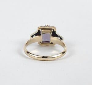 Gold ring with a purple gemstone.