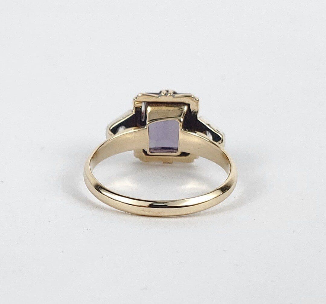 Gold ring with a purple gemstone.