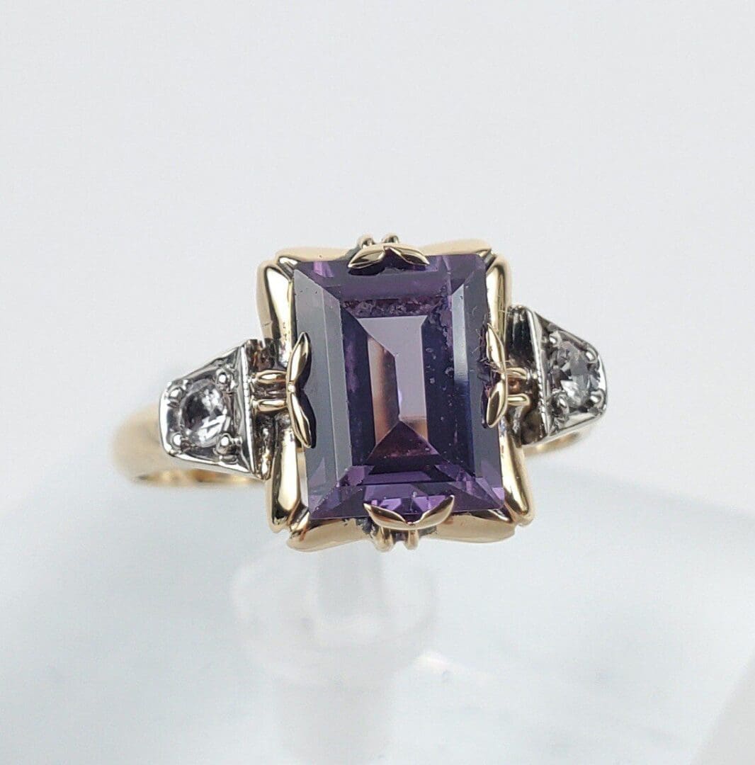 Gold ring with large purple gemstone.