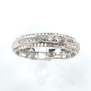 Silver diamond-studded ring on display stand.