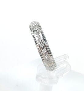Silver ring with embedded diamonds on display.