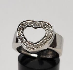 Silver ring with heart-shaped diamond design.