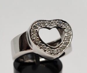 Silver ring with heart-shaped diamond design.