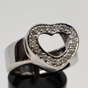 Silver ring with heart-shaped diamond design.