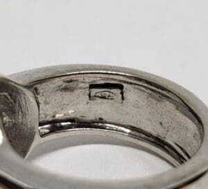 Close-up of a silver ring with hallmark.