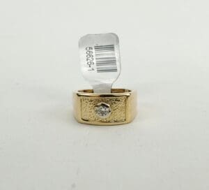 Gold ring with diamond and price tag.