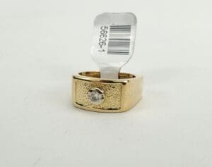 Gold ring with diamond and price tag.