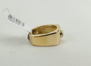 Gold ring with a price tag attached.