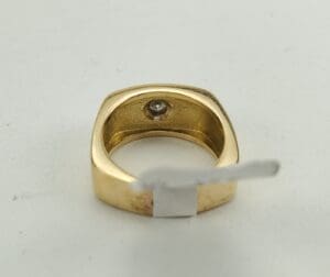 Gold ring with a gemstone inside band.
