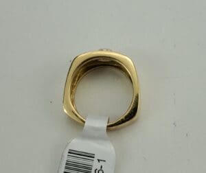 Gold ring with square band and tag.