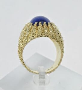 Gold ring with blue gemstone detail.