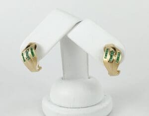 Gold earrings with green gemstone accents.