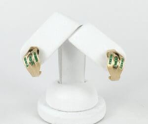 Gold earrings with green gemstone accents.