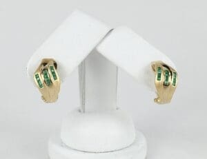 Gold earrings with green gemstone accents.