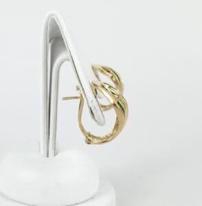 Gold hoop earrings on a white stand.